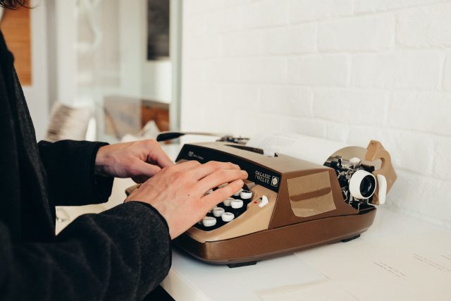 Author website services person typing on a typewriter